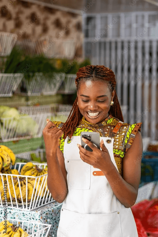 Commerçante sénégalaise consultant l'application Yonima Vendeur sur son étal au marché de Dakar